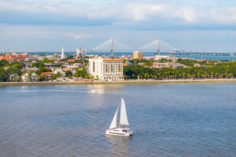 Slide: The Image of Sailboat Bali 4.2 cruising near cityscape with bridge in background, 2023. - 6