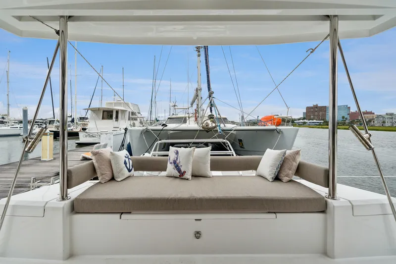 Slide: The Image of Luxurious Bali 4.2 catamaran with cushioned seating, docked at a marina, 2023 model. - 68