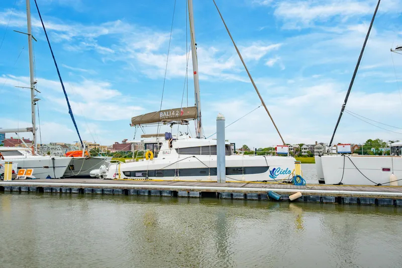 Slide: The Image of 2023 Bali 4.2 catamaran docked at marina under clear blue sky. - 7