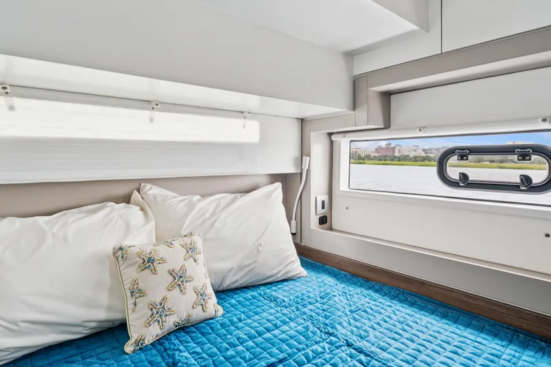 Slide: The Image of Cozy cabin interior of 2023 Bali 4.2 yacht with blue bedding and starfish pillow. - 77