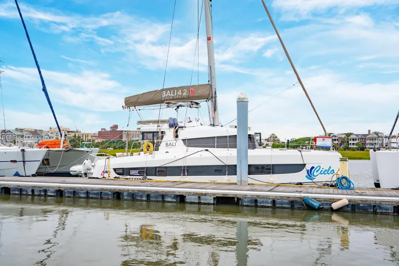 Slide: The Image of 2023 Bali 4.2 catamaran docked at marina under clear blue sky. - 8