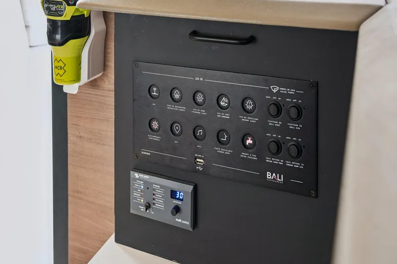 Slide: The Image of Control panel of a 2023 Bali 4.2 catamaran with various switches and indicators. - 81