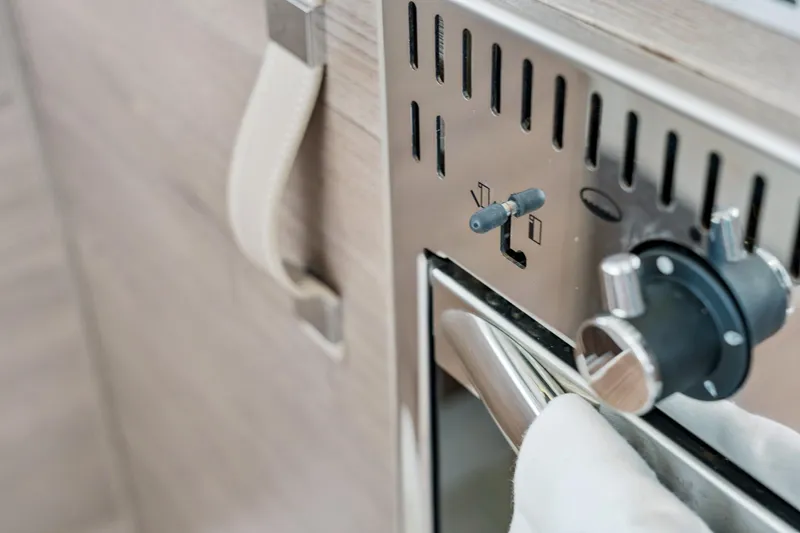 Slide: The Image of Close-up of a Bali 4.2 oven control panel, 2023 model, with handle and knobs. - 84