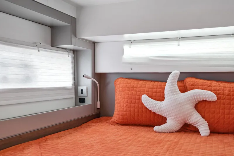 Slide: The Image of Cozy Bali 4.2 yacht cabin with orange bedding and starfish pillow, 2023 model. - 85