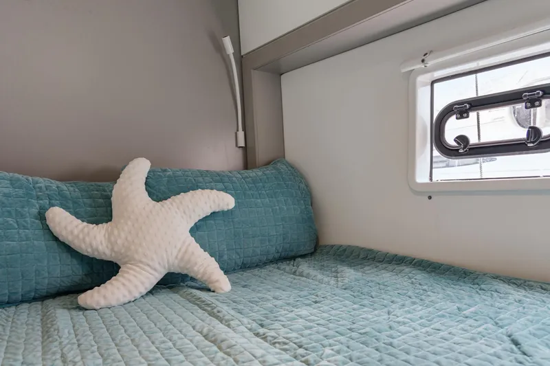 Slide: The Image of Cozy cabin bed in 2023 Bali 4.2 yacht with starfish pillow and window view. - 86