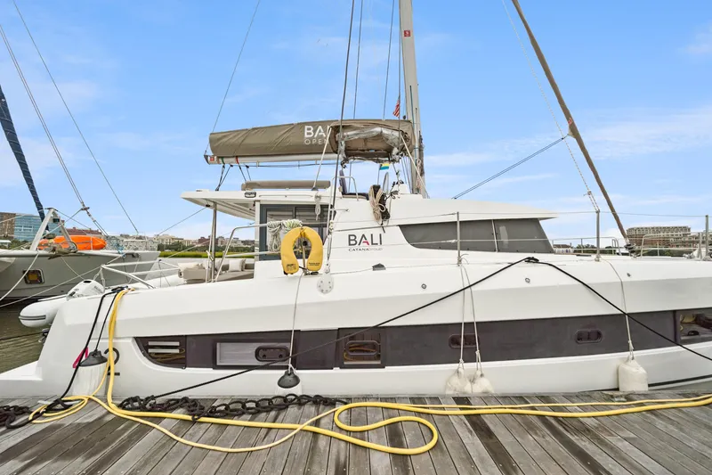 Slide: The Image of 2023 Bali 4.2 catamaran docked at marina, side view with clear sky. - 9
