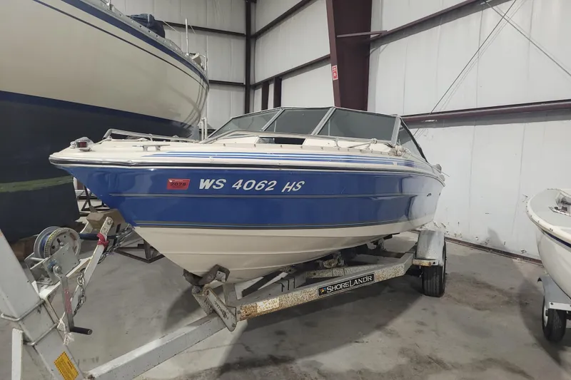 Slide: The Image of 1986 Sea Ray Seville 18 Bowrider boat on trailer in indoor storage. - 0