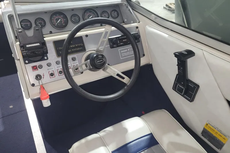 Slide: The Image of 1986 Sea Ray Seville 18 Bowrider dashboard with steering wheel and control panel. - 5