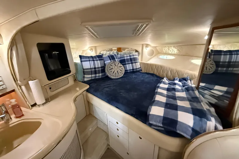 Slide: The Image of Interior cabin of 2001 Sea Ray 310 Sundancer with cozy bed and nautical decor. - 10