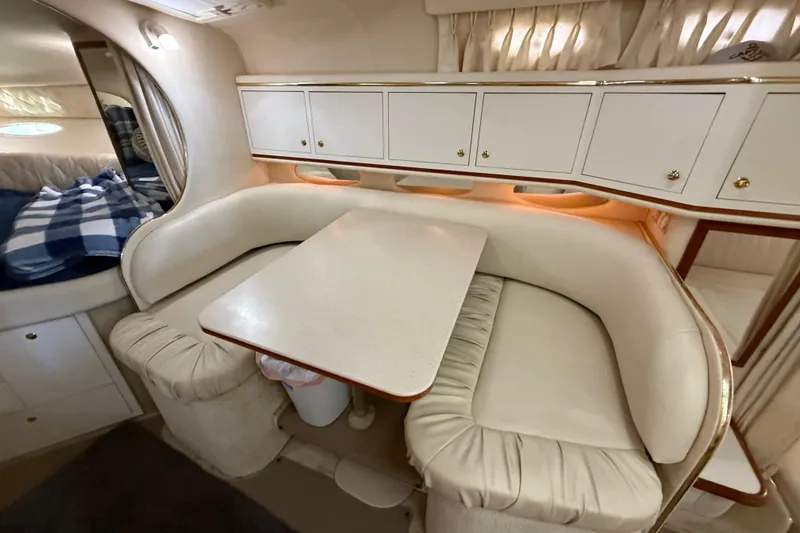 Slide: The Image of 2001 Sea Ray 310 Sundancer interior with cozy dining area and white cabinetry. - 11