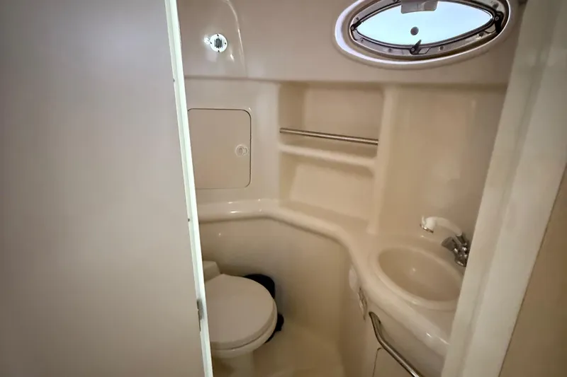 Slide: The Image of Compact bathroom in 2001 Sea Ray 310 Sundancer yacht with toilet, sink, and porthole. - 13