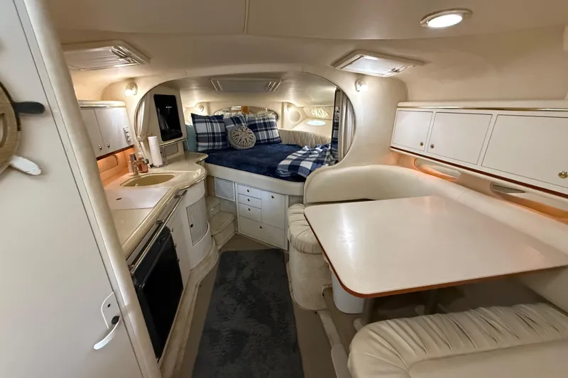Slide: The Image of Interior of 2001 Sea Ray 310 Sundancer yacht with cozy cabin and dining area. - 14