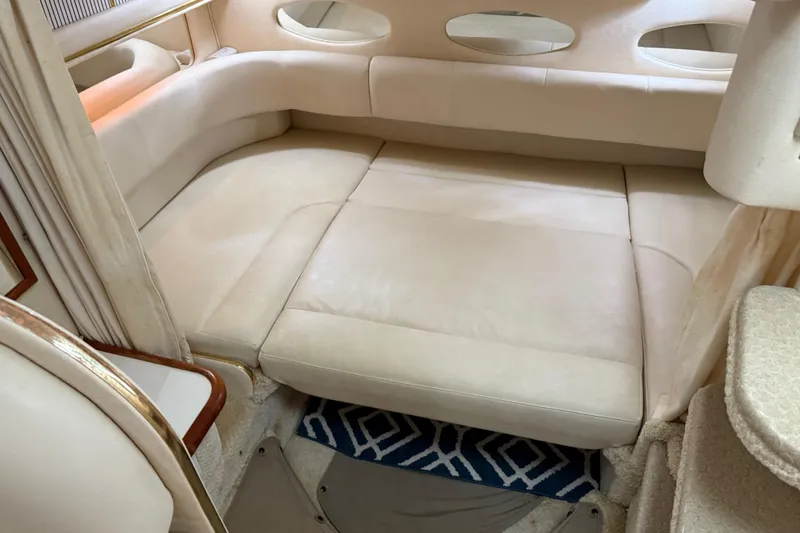 Slide: The Image of 2001 Sea Ray 310 Sundancer interior with beige seating and oval windows. - 15