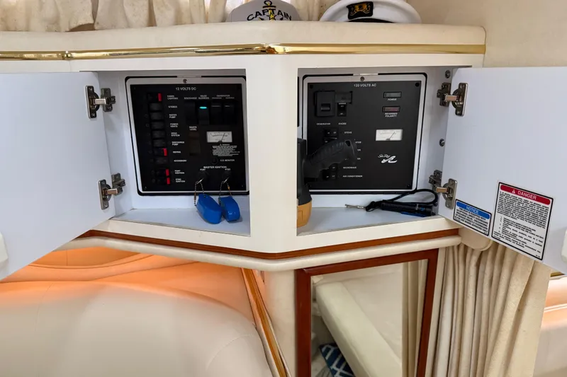 Slide: The Image of Electrical panel inside a 2001 Sea Ray 310 Sundancer boat, featuring control switches and safety labels. - 16