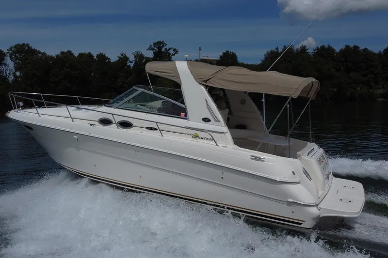 Slide: The Image of 2001 Sea Ray 310 Sundancer cruising on a lake with trees in the background. - 7