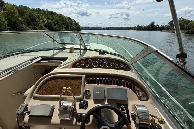 Slide: The Image of 2001 Sea Ray 310 Sundancer helm view on a scenic river cruise. - 9