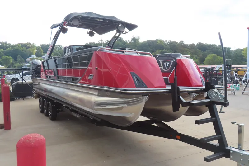 Slide: The Image of 2024 Trifecta 25Sport RF9 DC 3.0 Plus pontoon boat on trailer, vibrant red design. - 4