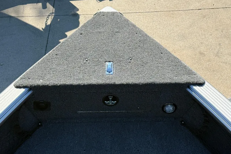 Slide: The Image of 2026 Lund 1875 Pro Guide boat interior with carpeted deck and storage compartments. - 11