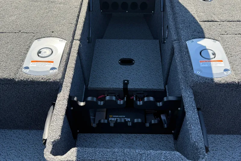 Slide: The Image of 2026 Lund 1875 Pro Guide boat interior with storage compartments and Minn Kota battery system. - 14