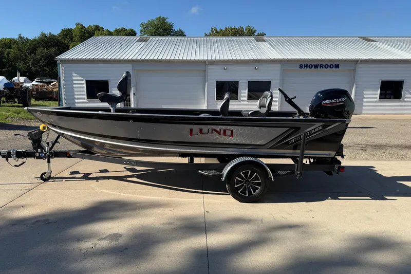 Slide: The Image of 2026 Lund 1875 Pro Guide boat on trailer outside showroom. - 4