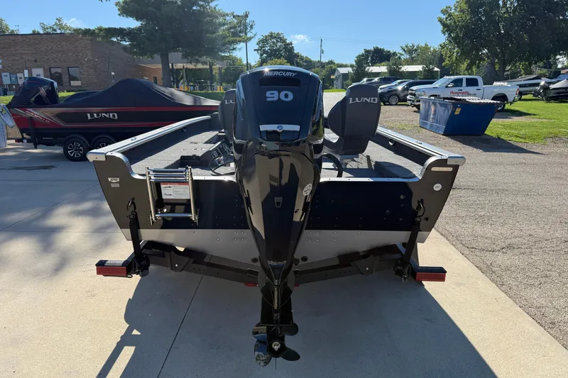 Slide: The Image of 2026 Lund 1875 Pro Guide boat with Mercury 90 engine, parked outdoors. - 6