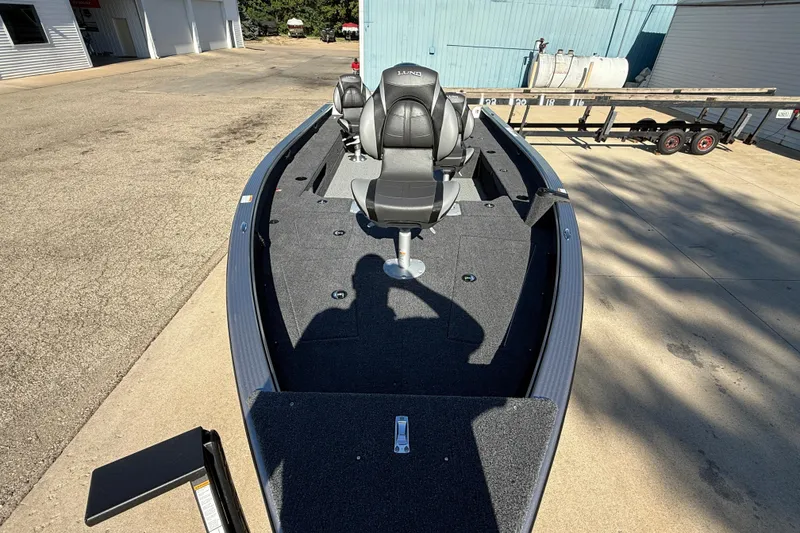 Slide: The Image of 2026 Lund 1875 Pro Guide boat with seating, parked on a concrete surface. - 8