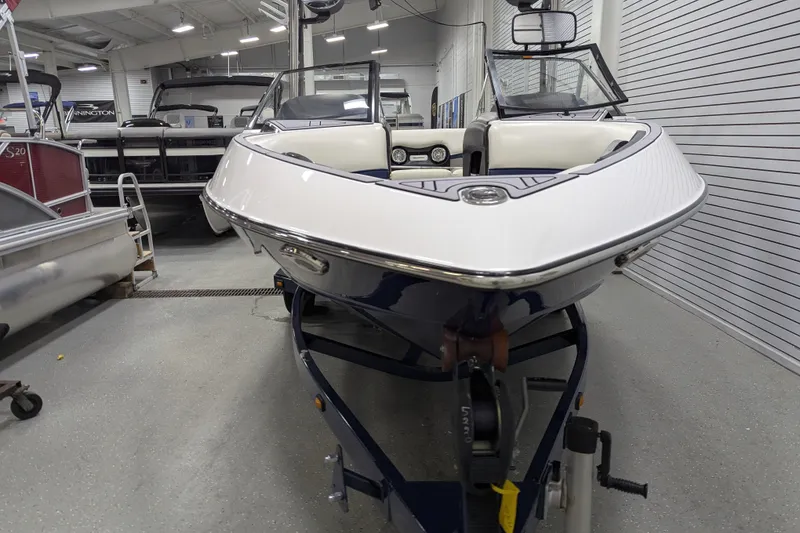 Slide: The Image of 2012 Malibu Wakesetter VLX boat in showroom, front view, on trailer. - 10