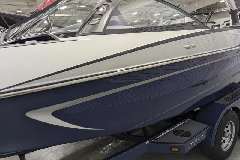 Slide: The Image of 2012 Malibu Wakesetter VLX boat on trailer in indoor showroom. - 13