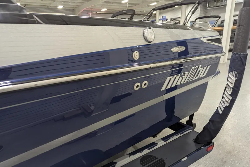 Slide: The Image of 2012 Malibu Wakesetter VLX boat in showroom, blue exterior with logo visible. - 15