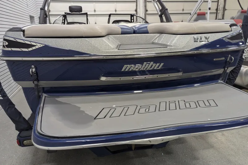 Slide: The Image of 2012 Malibu Wakesetter VLX boat rear view in a garage setting. - 17