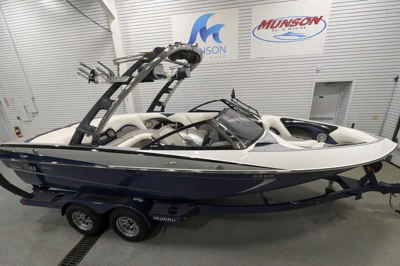 Slide: The Image of 2012 Malibu Wakesetter VLX boat in showroom, featuring sleek design and modern wakeboard tower. - 24