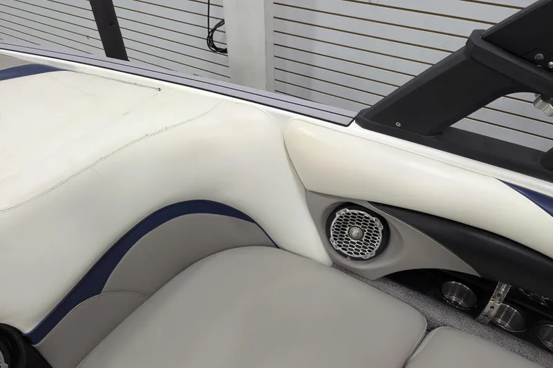 Slide: The Image of 2012 Malibu Wakesetter VLX interior with white and gray seating, speaker, and cup holders. - 26
