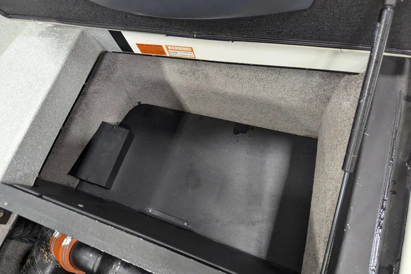 Slide: The Image of 2012 Malibu Wakesetter VLX storage compartment, open and empty, with visible warning label. - 39