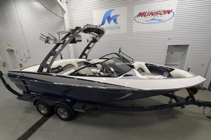 Slide: The Image of 2012 Malibu Wakesetter VLX boat in showroom, featuring sleek design and modern wakeboarding equipment. - 4
