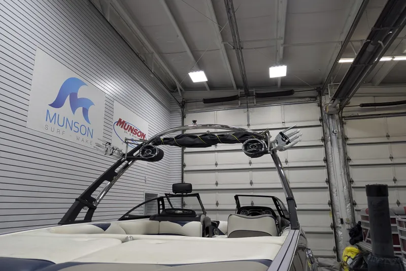 Slide: The Image of 2012 Malibu Wakesetter VLX boat in a garage, Munson Surf Wake signage visible. - 40