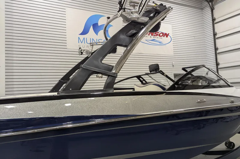 Slide: The Image of 2012 Malibu Wakesetter VLX boat in showroom, featuring sleek design and modern wakeboard tower. - 6
