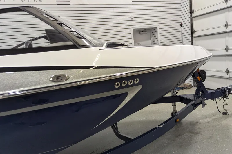 Slide: The Image of 2012 Malibu Wakesetter VLX boat on trailer in garage setting. - 8