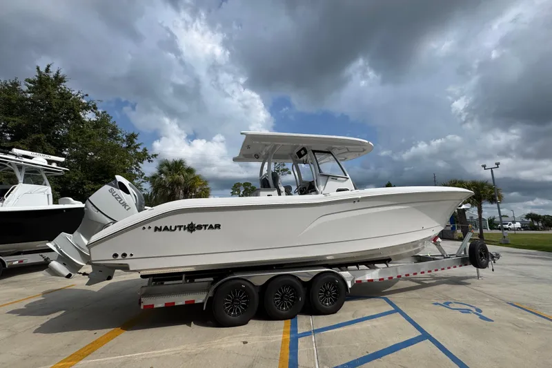 Slide: The Image of 2026 NauticStar 332 Offshore boat on trailer under cloudy sky. - 10