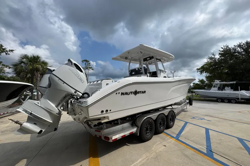 Slide: The Image of 2026 NauticStar 332 Offshore boat on trailer under cloudy sky. - 11