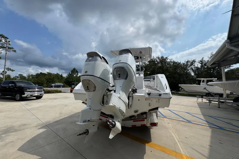 Slide: The Image of 2026 NauticStar 332 Offshore boat with dual outboard engines in a parking area. - 13