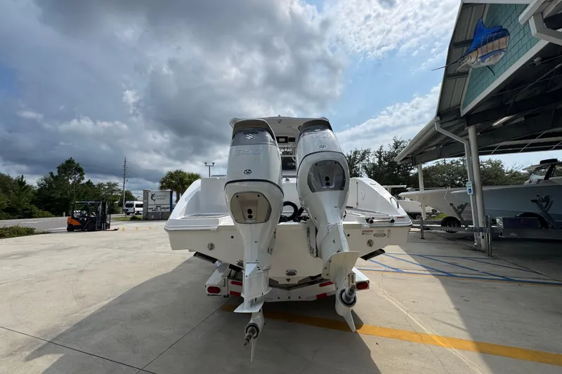 Slide: The Image of 2026 NauticStar 332 Offshore boat with dual outboard motors at a marina. - 14