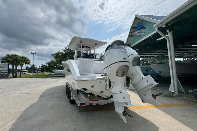 Slide: The Image of 2026 NauticStar 332 Offshore boat with dual engines, parked outdoors under cloudy sky. - 15