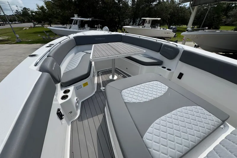 Slide: The Image of 2026 NauticStar 332 Offshore boat interior with cushioned seating and table. - 20