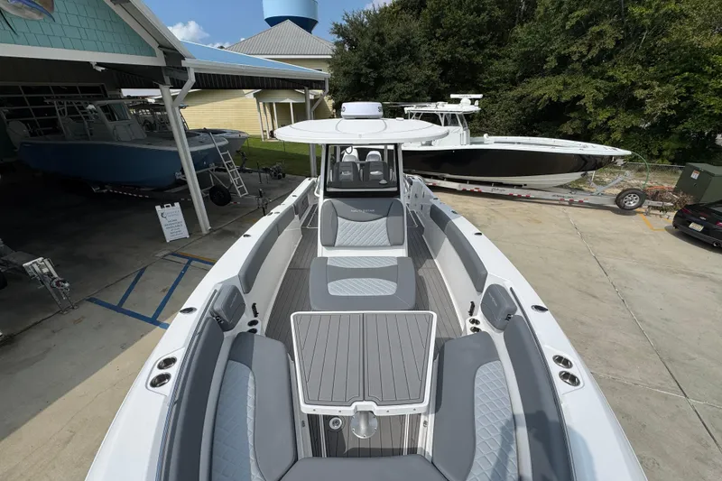 Slide: The Image of 2026 NauticStar 332 Offshore boat with sleek design and spacious seating at a marina. - 22
