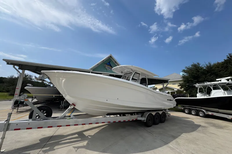 Slide: The Image of 2026 NauticStar 332 Offshore boat on trailer under clear blue sky. - 3