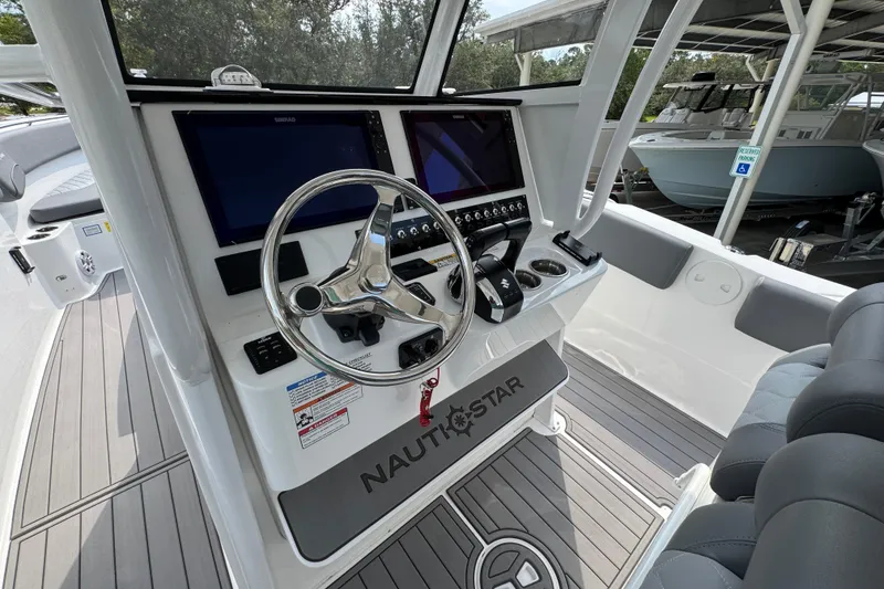 Slide: The Image of 2026 NauticStar 332 Offshore boat helm with dual screens and steering wheel. - 32