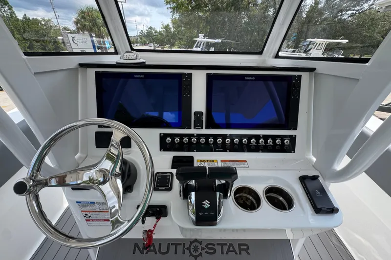Slide: The Image of Helm of 2026 NauticStar 332 Offshore with dual Simrad displays and controls. - 33