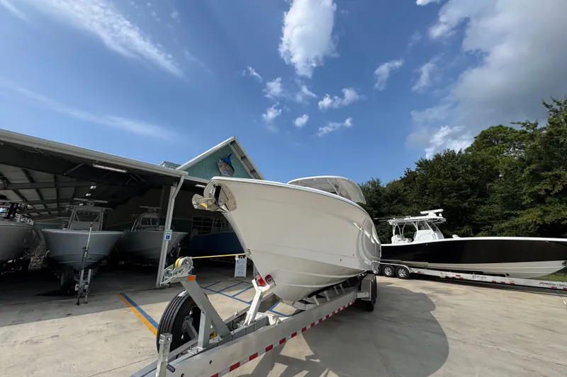 Slide: The Image of 2026 NauticStar 332 Offshore boat on trailer under clear blue sky. - 5