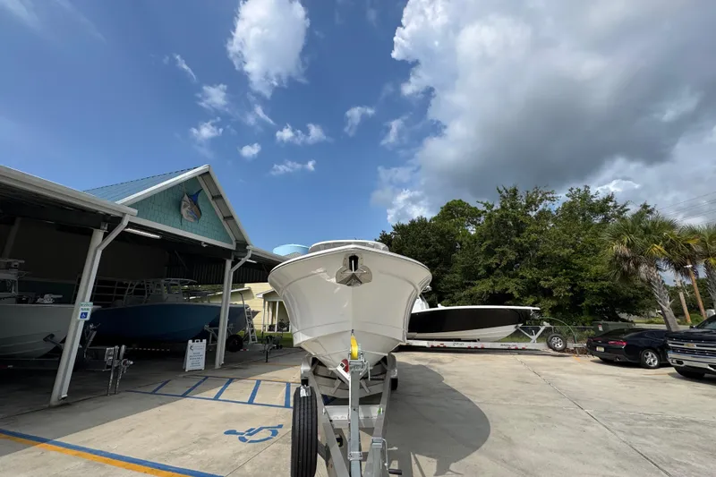 Slide: The Image of 2026 NauticStar 332 Offshore boat on trailer under blue sky. - 6