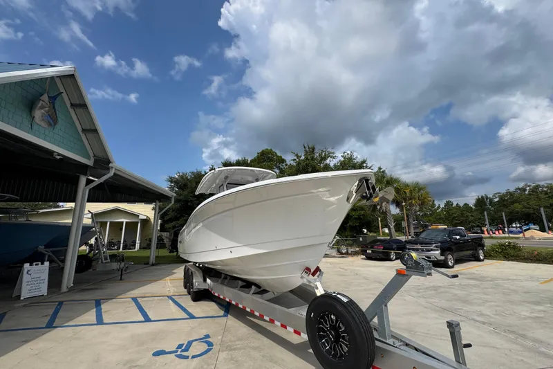 Slide: The Image of 2026 NauticStar 332 Offshore boat on trailer under cloudy sky. - 7